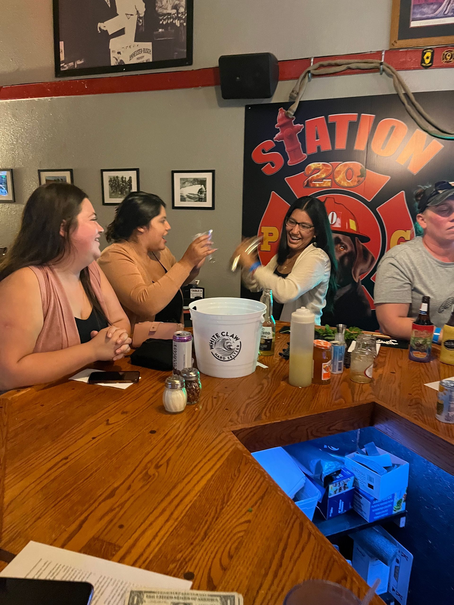 A group of people are sitting at a bar in front of a sign that says station 21