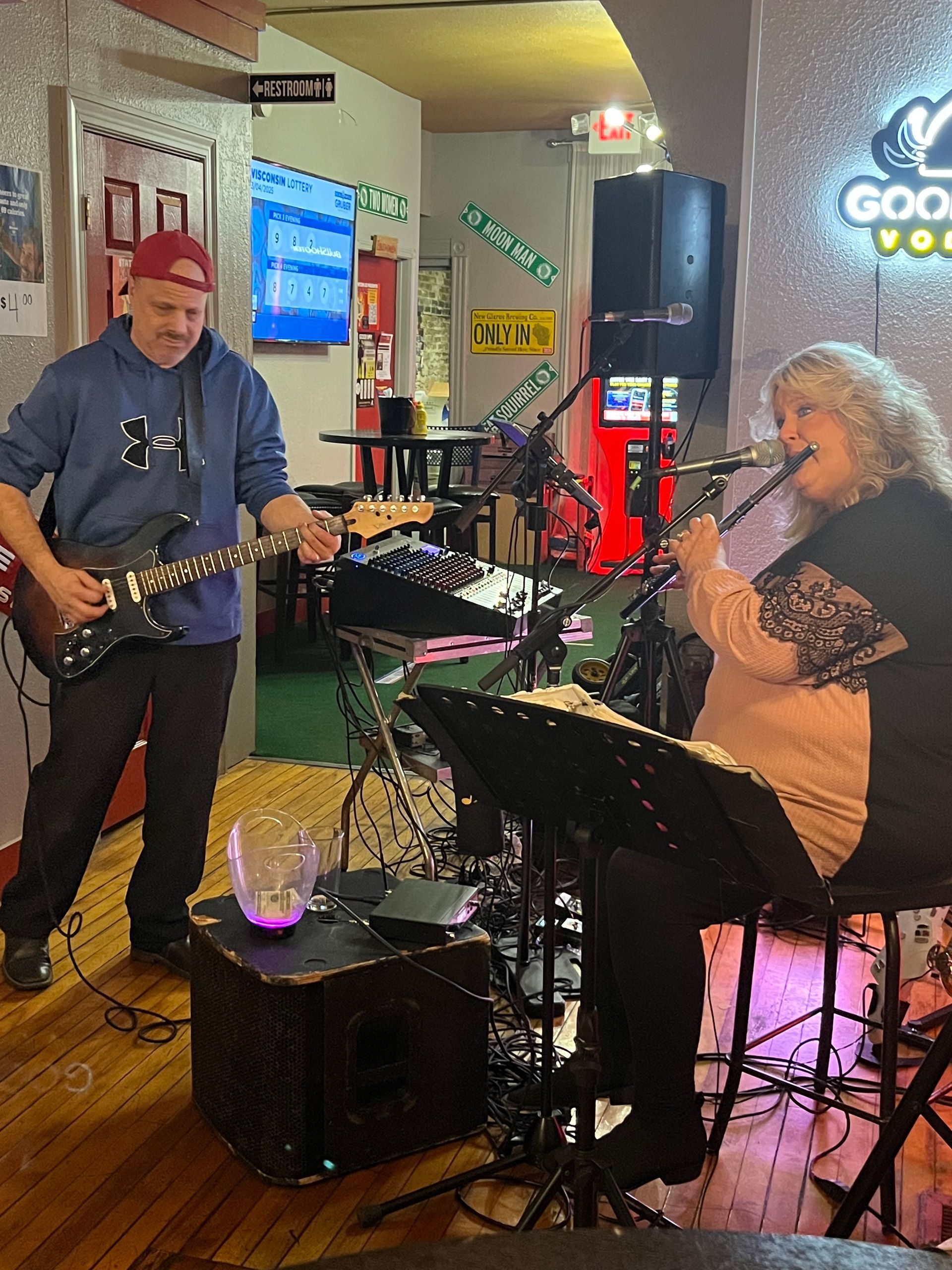 A man playing a guitar and a woman singing into a microphone