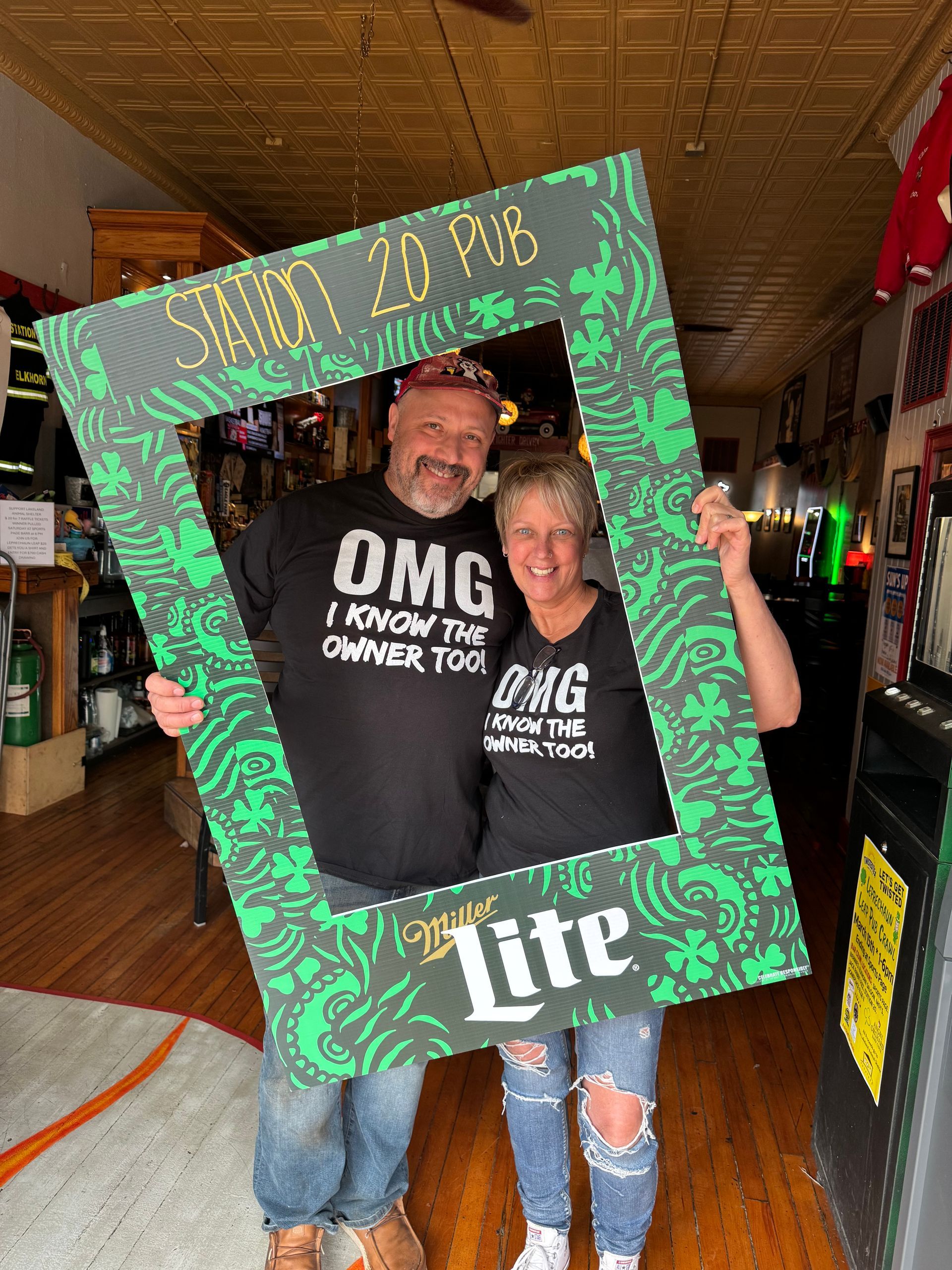 A man and a woman are posing for a picture with a sign that says lite on it.