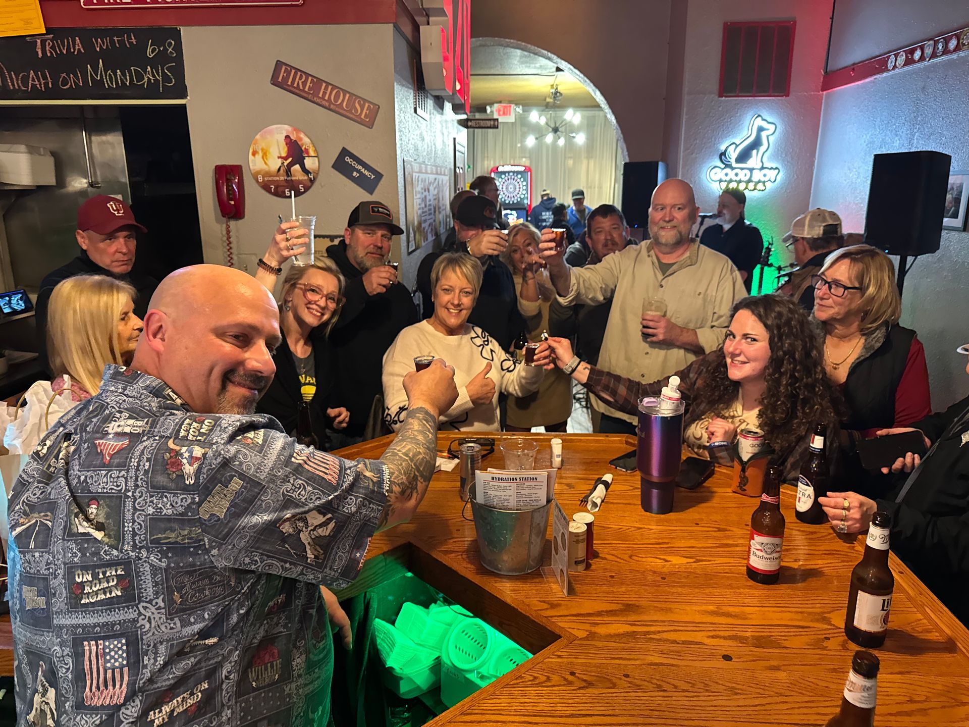 A group of people are sitting at a bar drinking beer.