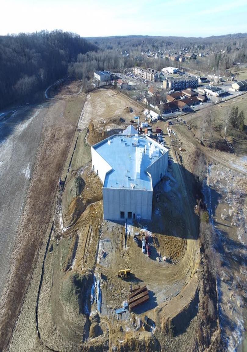 An aerial view of a building under construction in the middle of a field.