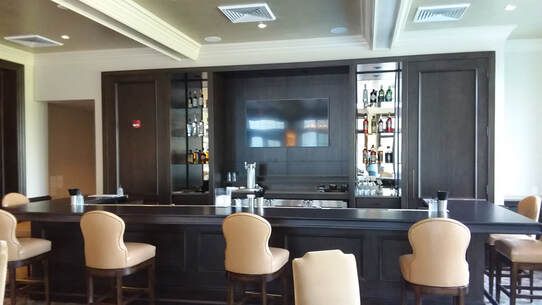 A large room with a bar and chairs in it