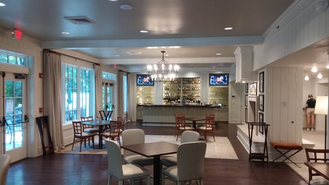 A large room with tables and chairs and a bar