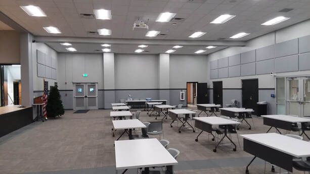 A large room with tables and chairs in it.