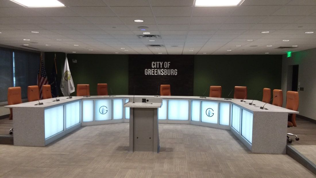 A conference room with a large table and chairs and a sign that says city of brothers
