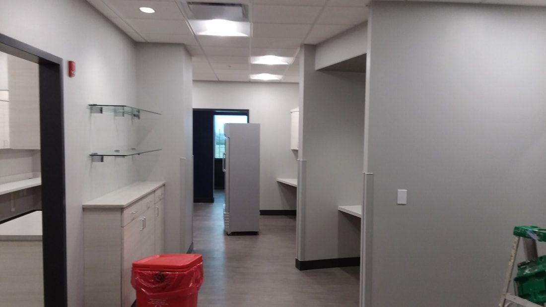 A hallway with a red trash can in the middle of it.