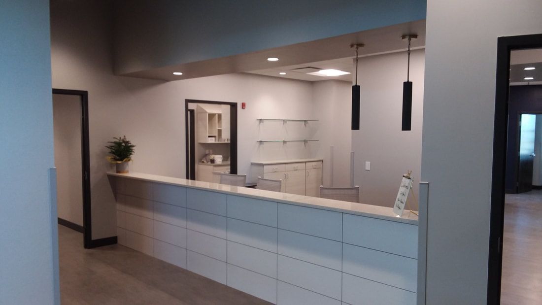 There is a long white counter in the middle of the room.