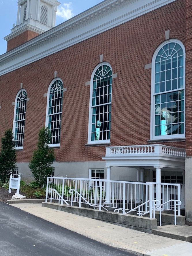 A large brick building with many windows and a white railing