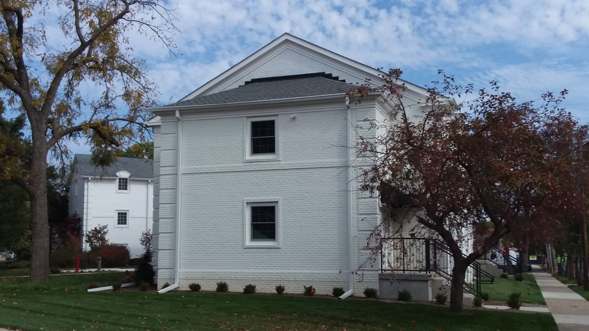 A white house with a tree in front of it