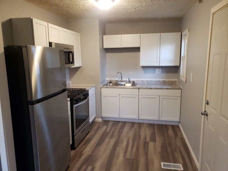 A kitchen with stainless steel appliances and white cabinets