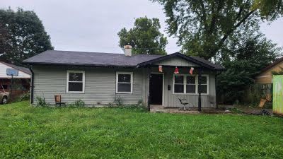 A small house with a lot of grass in front of it.