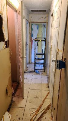 A hallway with a ladder in the middle of it.