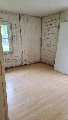 An empty room with wooden floors and white walls.
