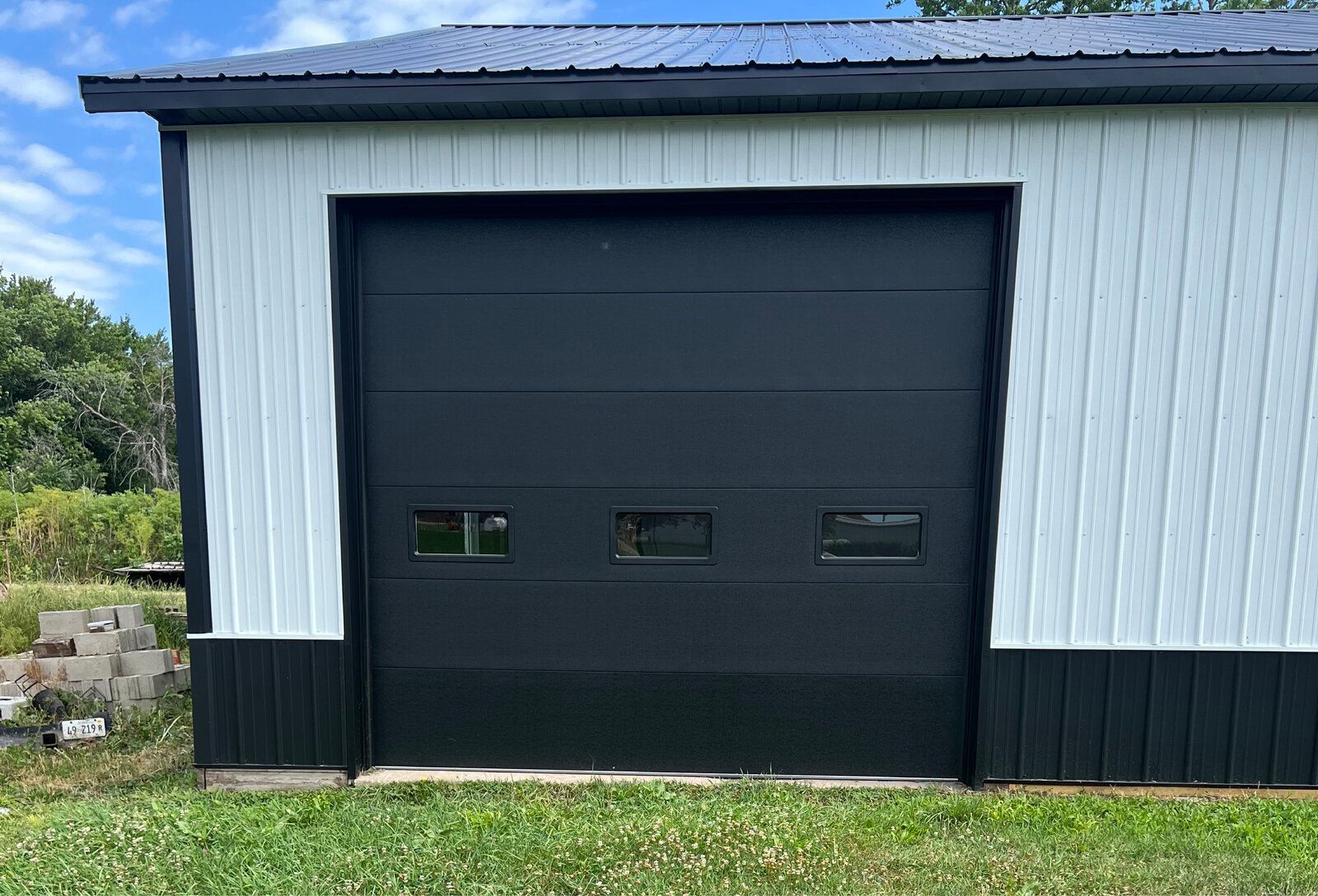A black and white garage with a black garage door.