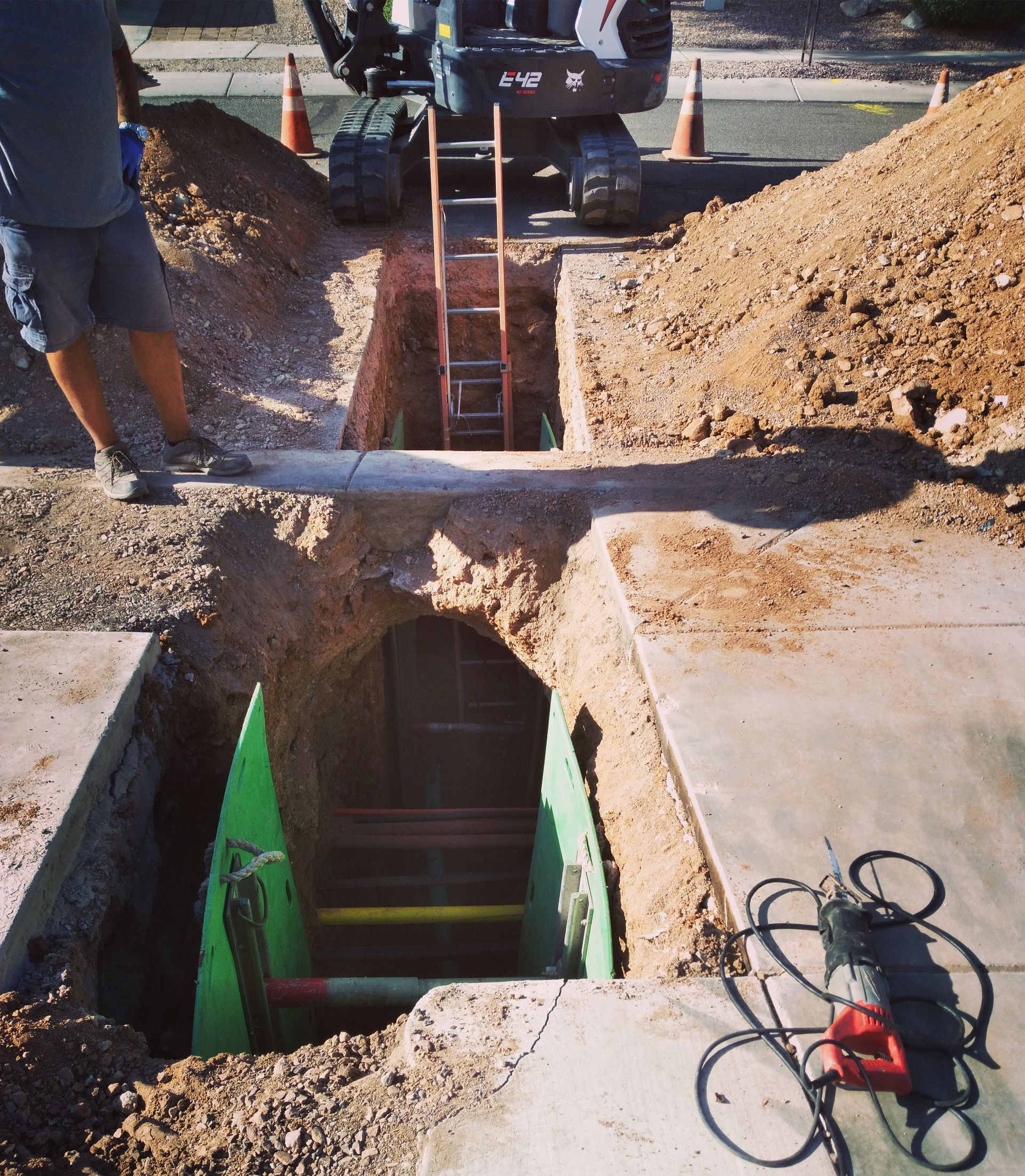 A man is working on a hole in the ground
