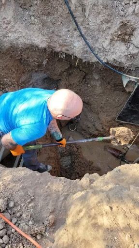 A man is digging a hole in the ground with a shovel.