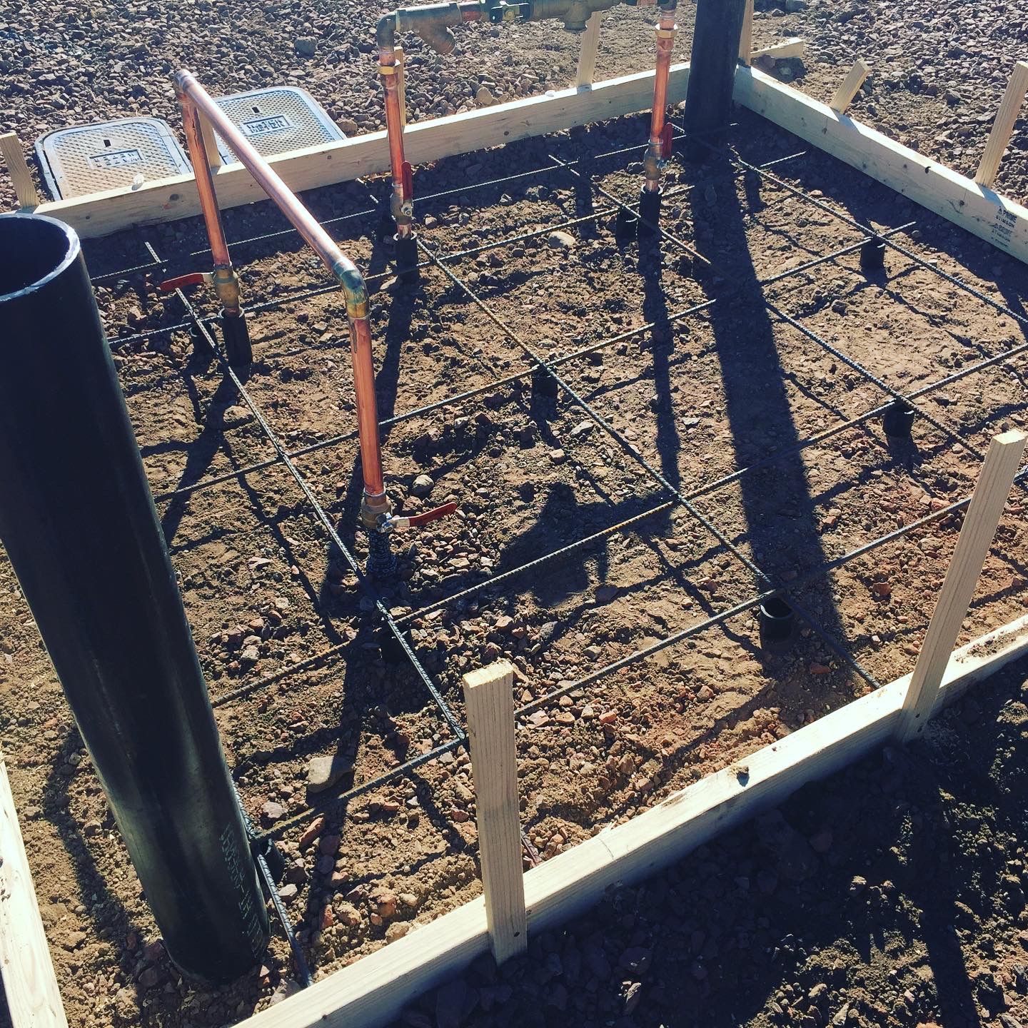 A black pipe is sitting in the middle of a concrete area