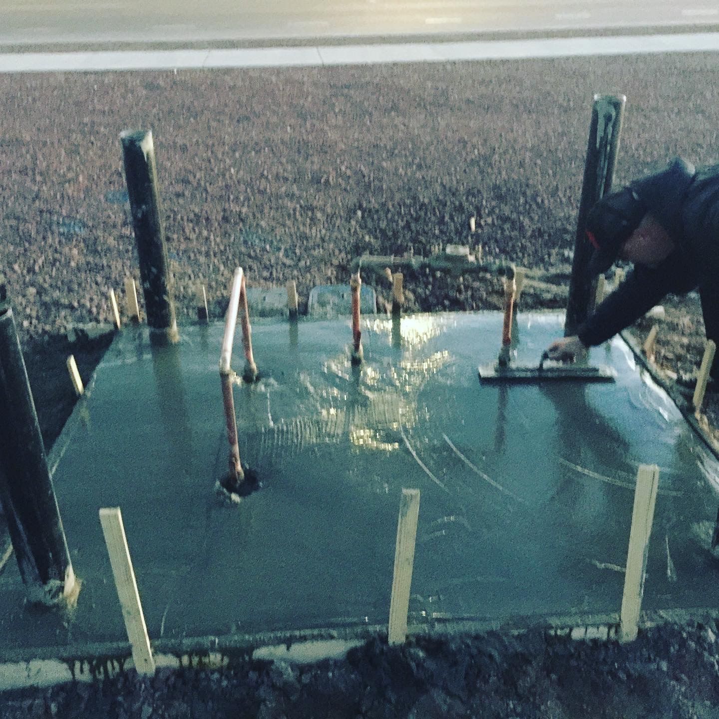 A man is working on a concrete surface with a trowel