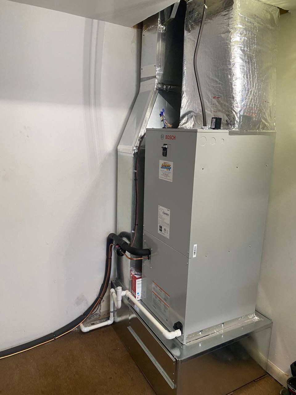 A large, gray HVAC unit with ductwork in a room.