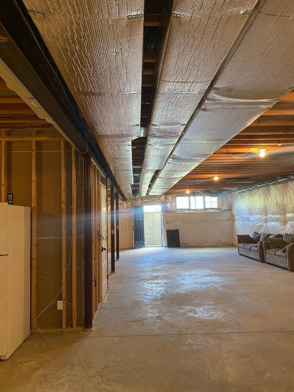 Basement with exposed framing, ductwork, and concrete floor. Walls are partially finished.