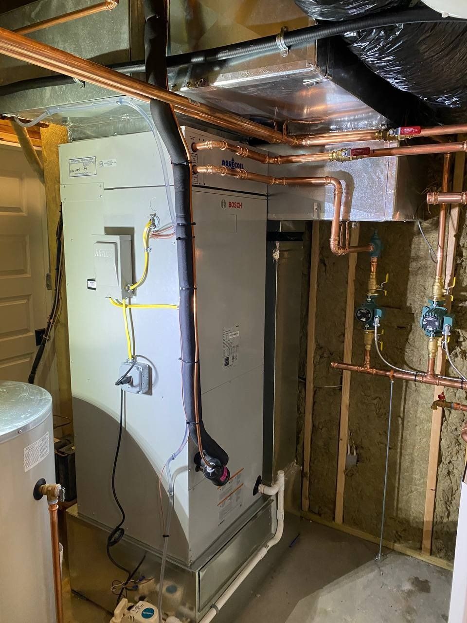 HVAC system in a basement. Grey furnace, copper pipes, and insulation are visible.