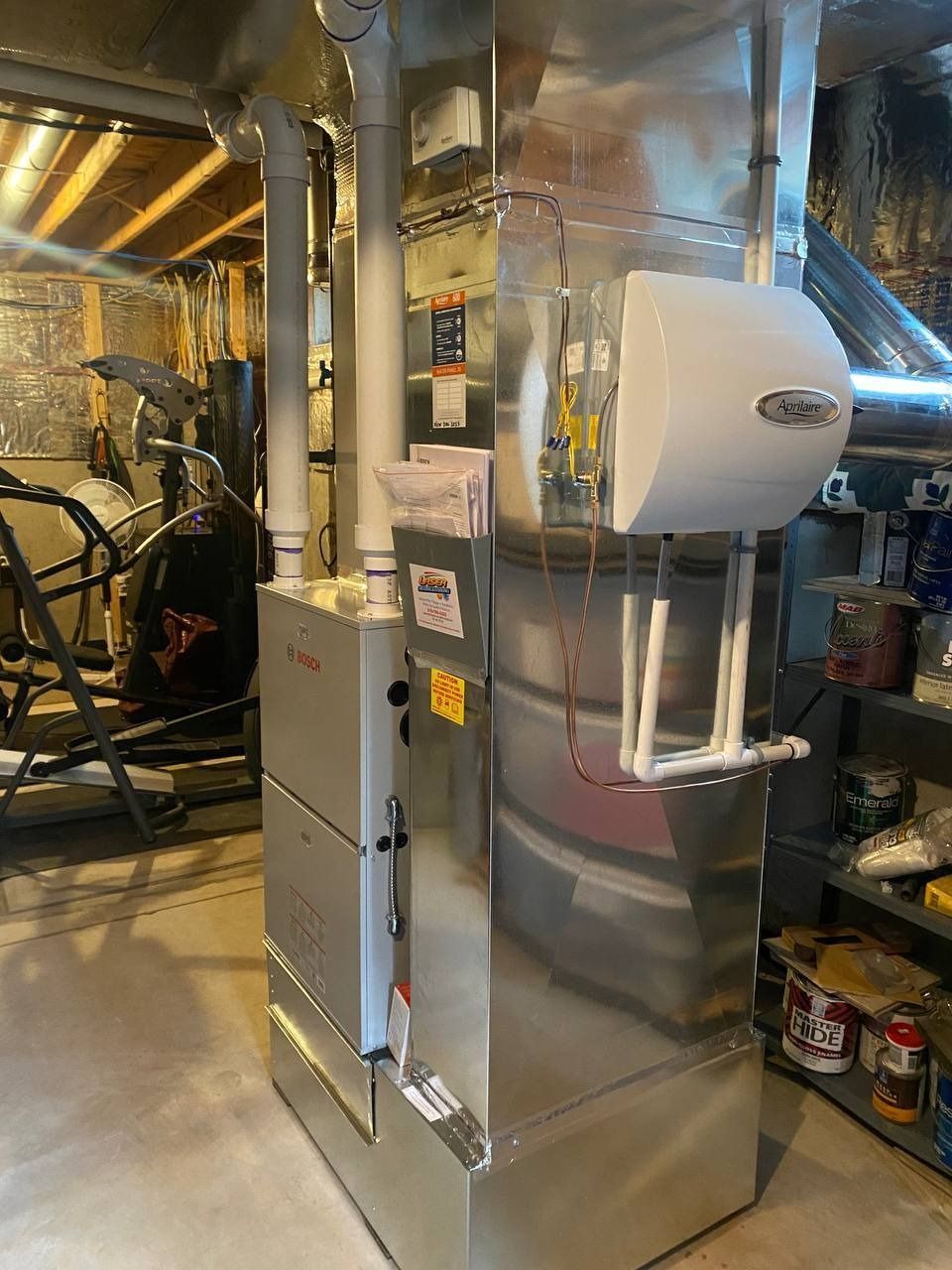 A Bosch furnace in a basement setting with ductwork and a humidifier attached.