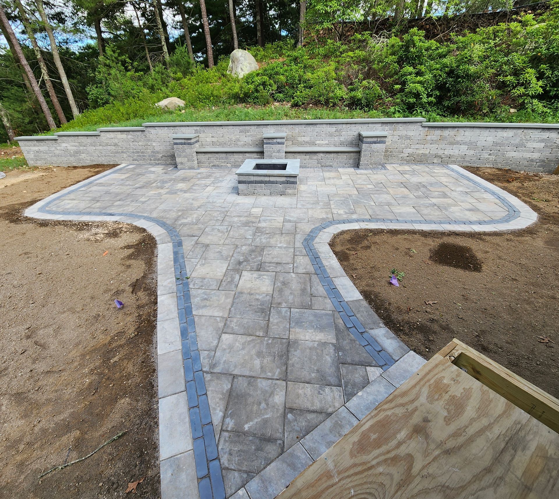 A brick walkway with a fire pit in the middle