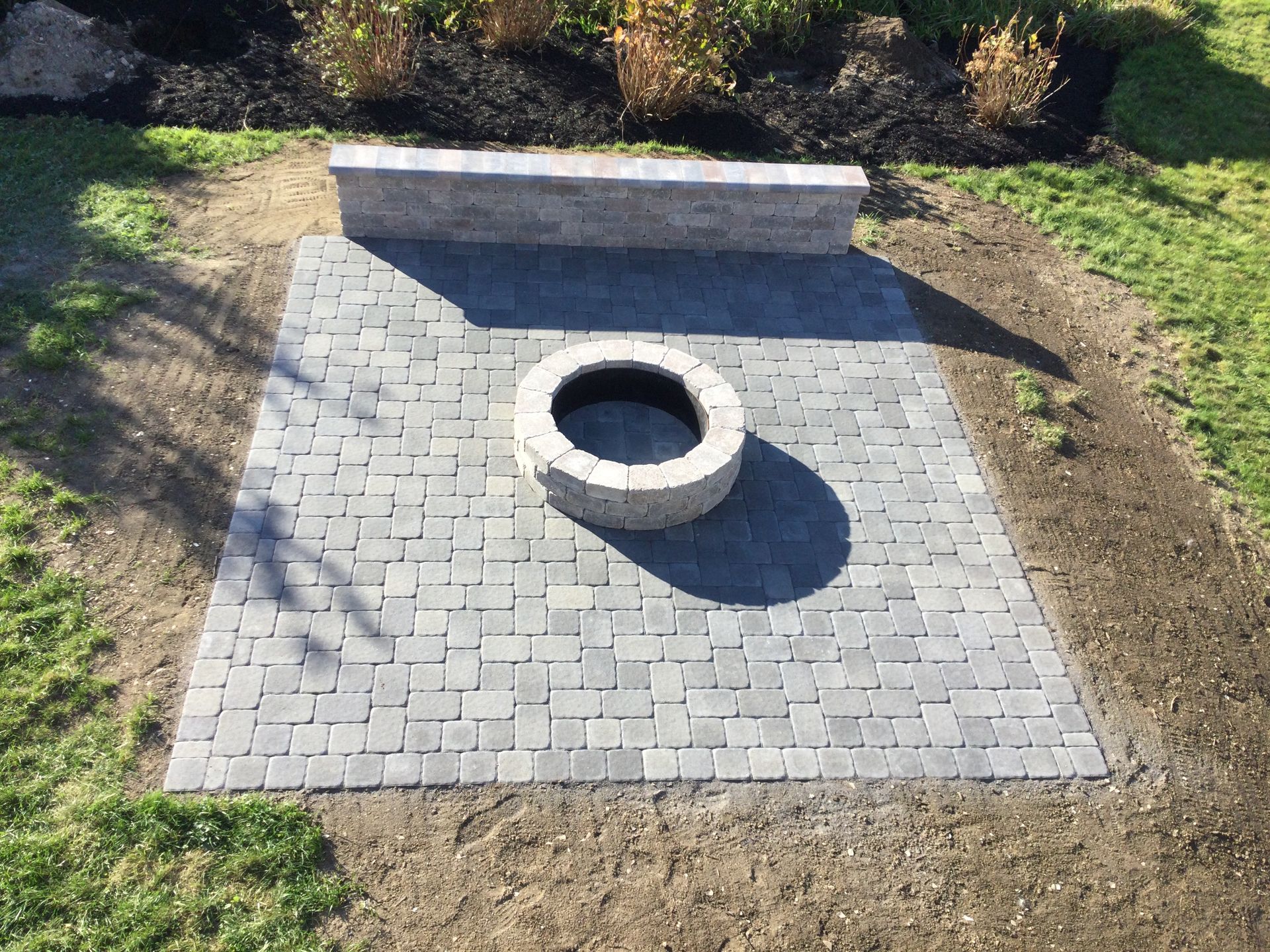 A fire pit is sitting in the middle of a brick patio