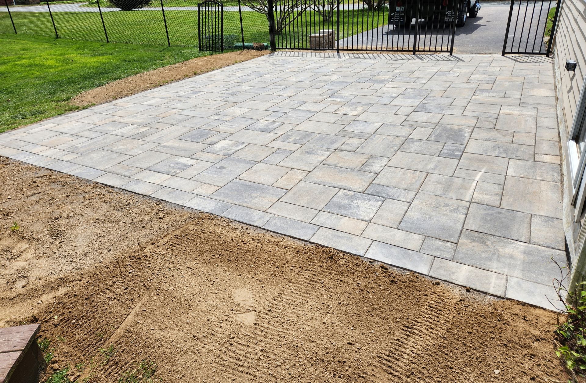 A brick driveway is being built in front of a house