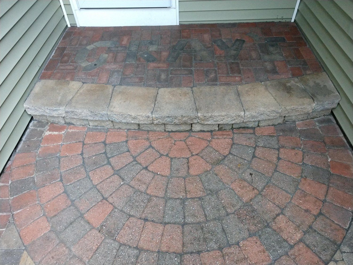 A brick walkway with a circular design in the middle