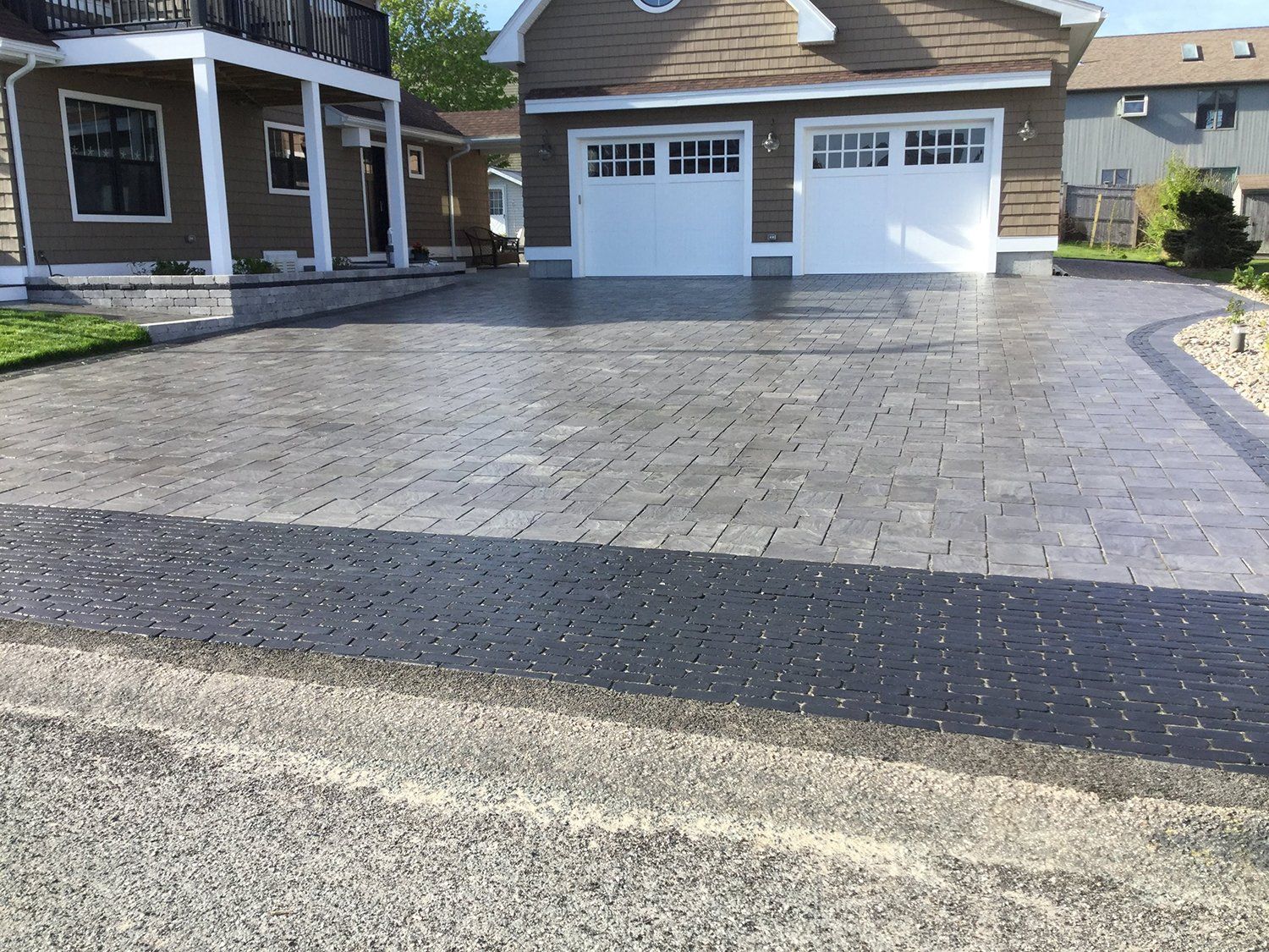 A driveway leading to a house with a garage door