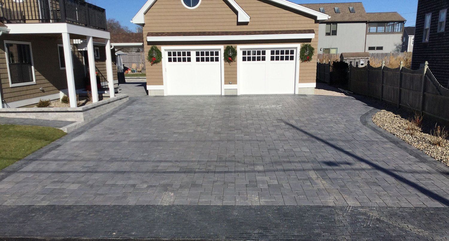 A driveway leading to a house with two garage doors