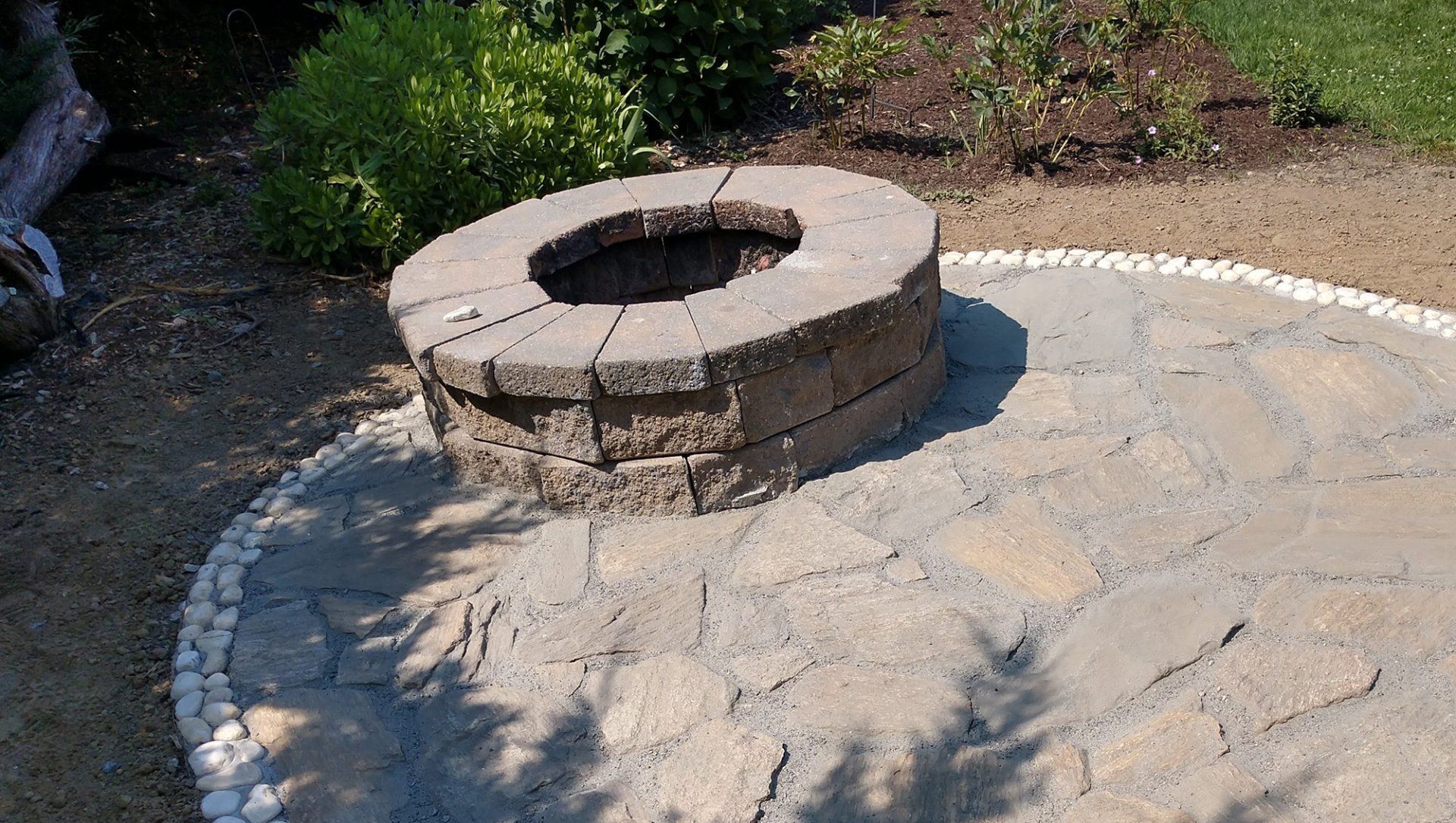 A fire pit is sitting on top of a stone patio