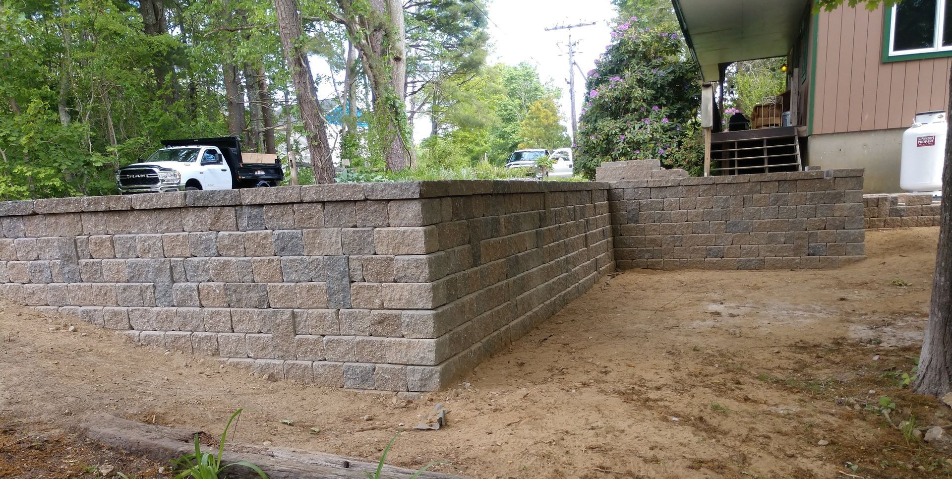 A brick wall is being built in front of a house.