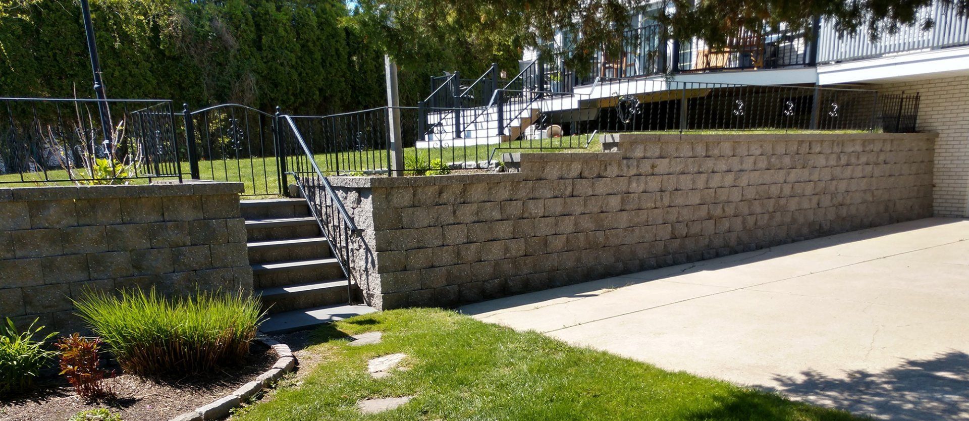A brick wall with stairs leading up to a house.