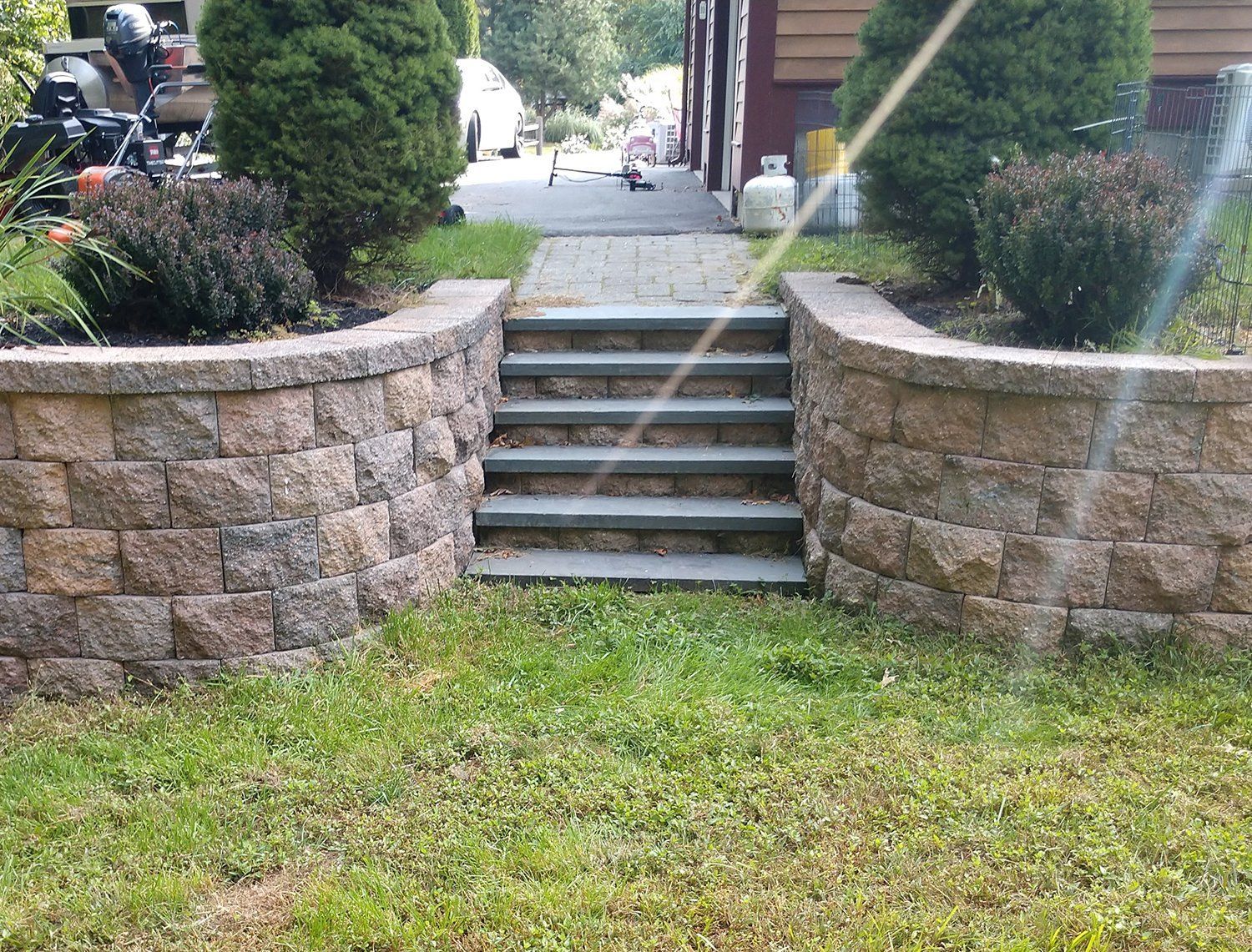 A stone wall with stairs leading up to a house