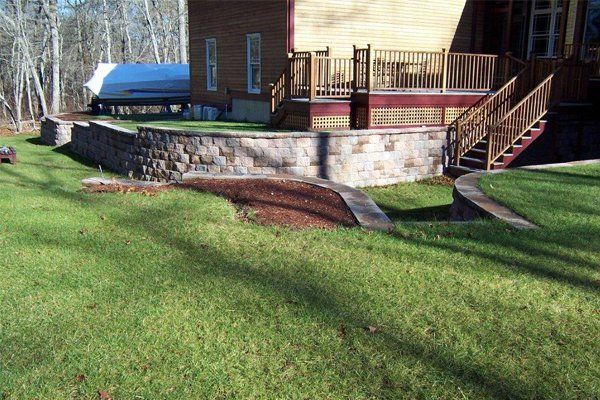 A house with a stone wall and stairs in front of it