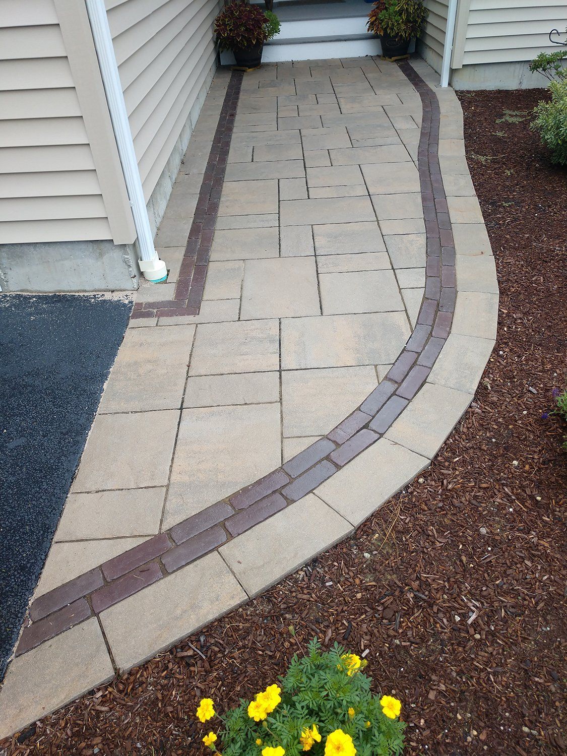 A brick walkway leading to the front door of a house.