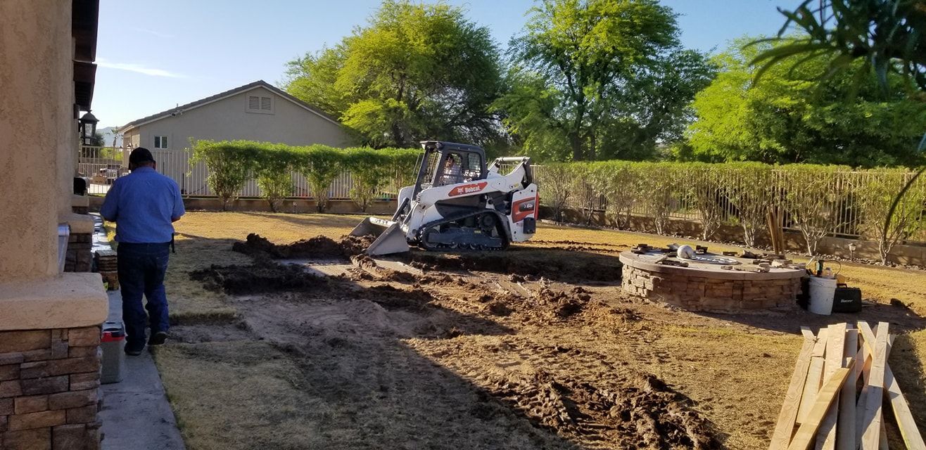 A man is standing in front of a bulldozer in a yard.