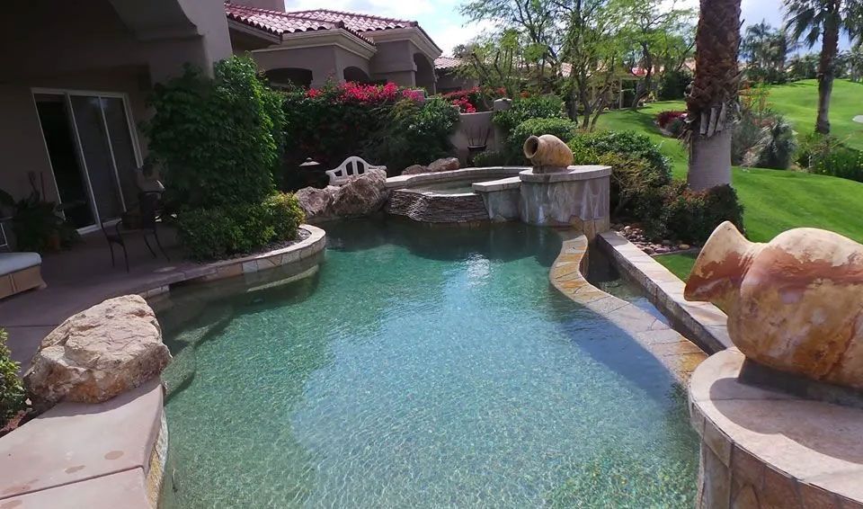 An aerial view of a large swimming pool in the backyard of a house.