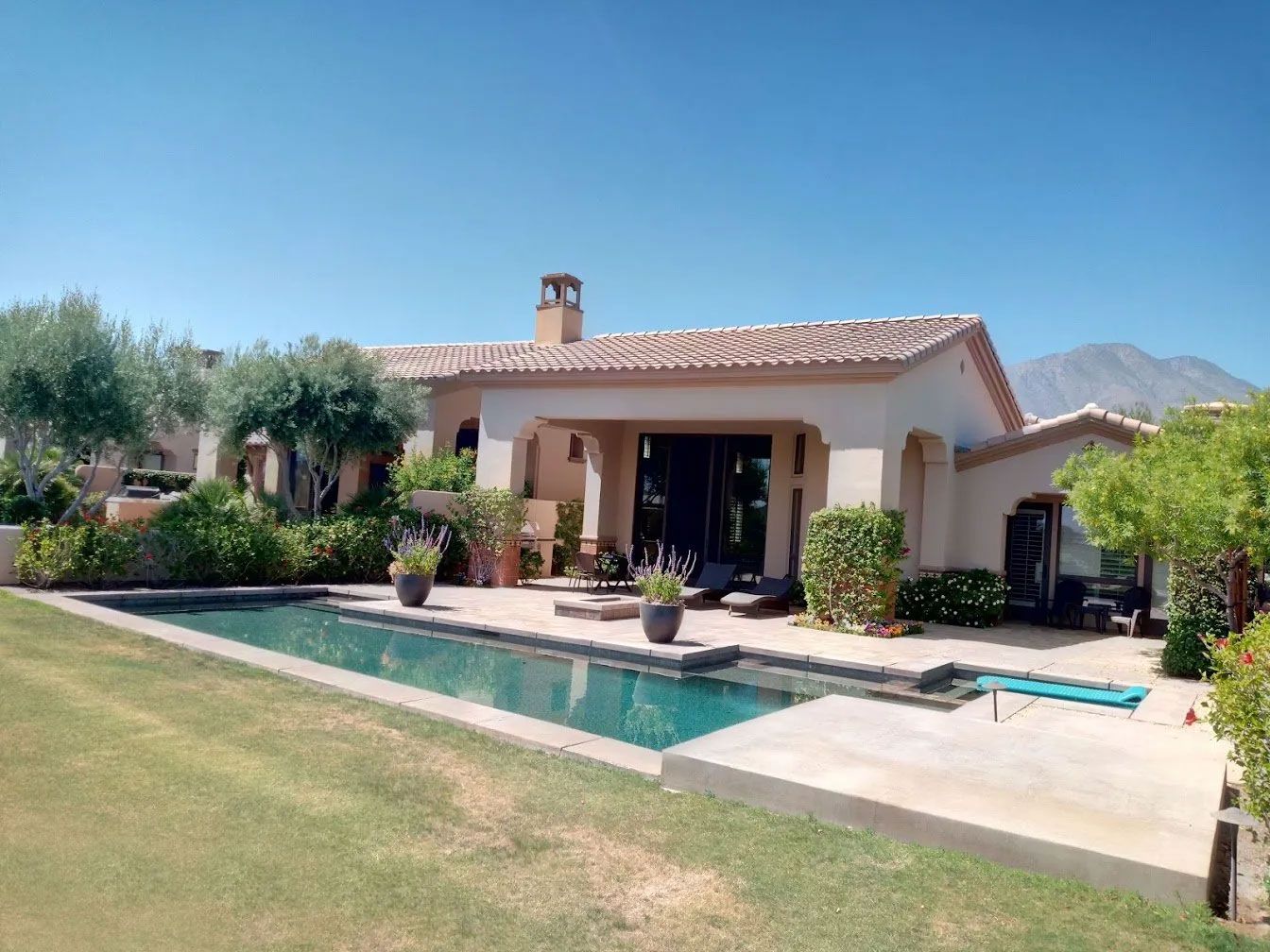 A house with a large swimming pool in front of it
