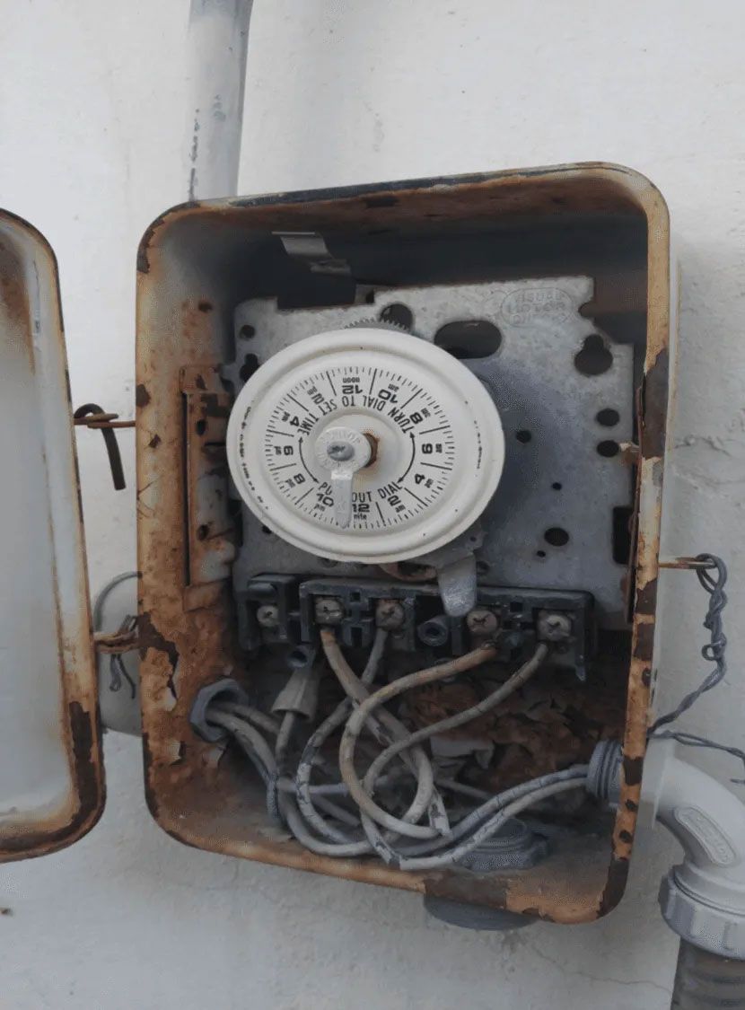 A rusty box with a clock inside of it