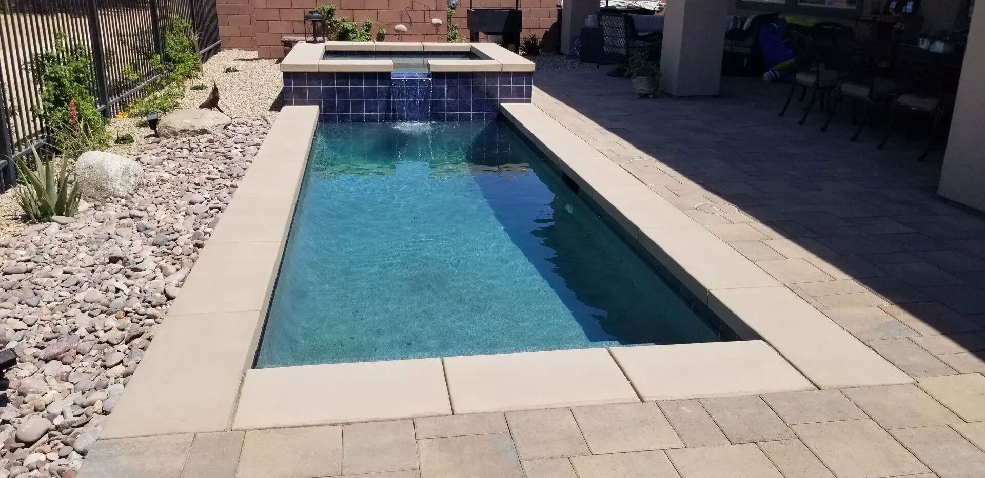 A swimming pool with a fountain in the middle of it