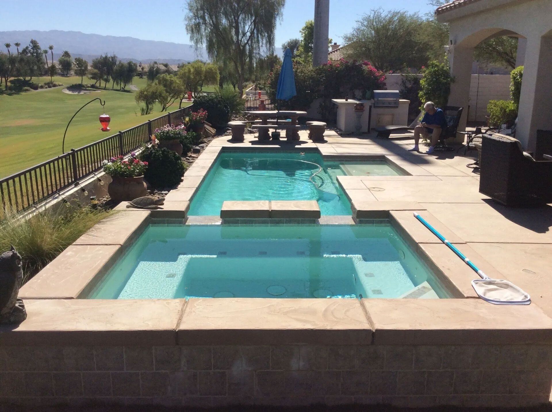 A large swimming pool with a hot tub in the middle