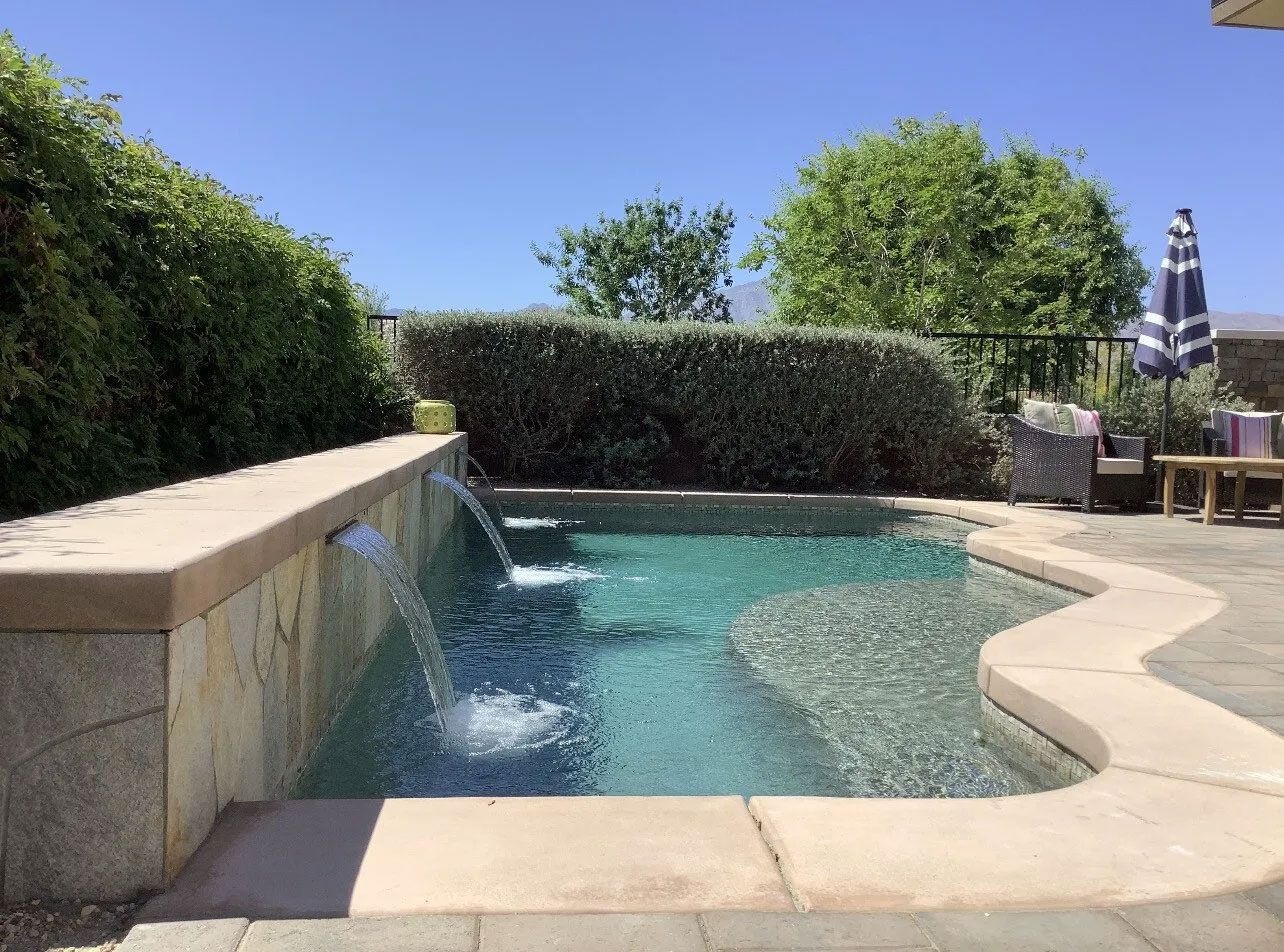 A swimming pool with a waterfall in the middle of it