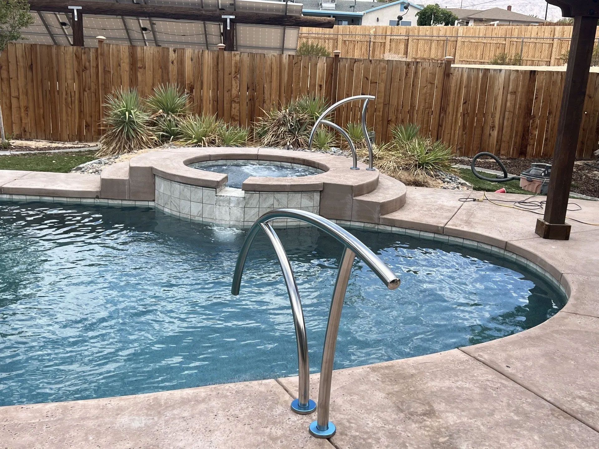 A large swimming pool with a hot tub in the middle of it.