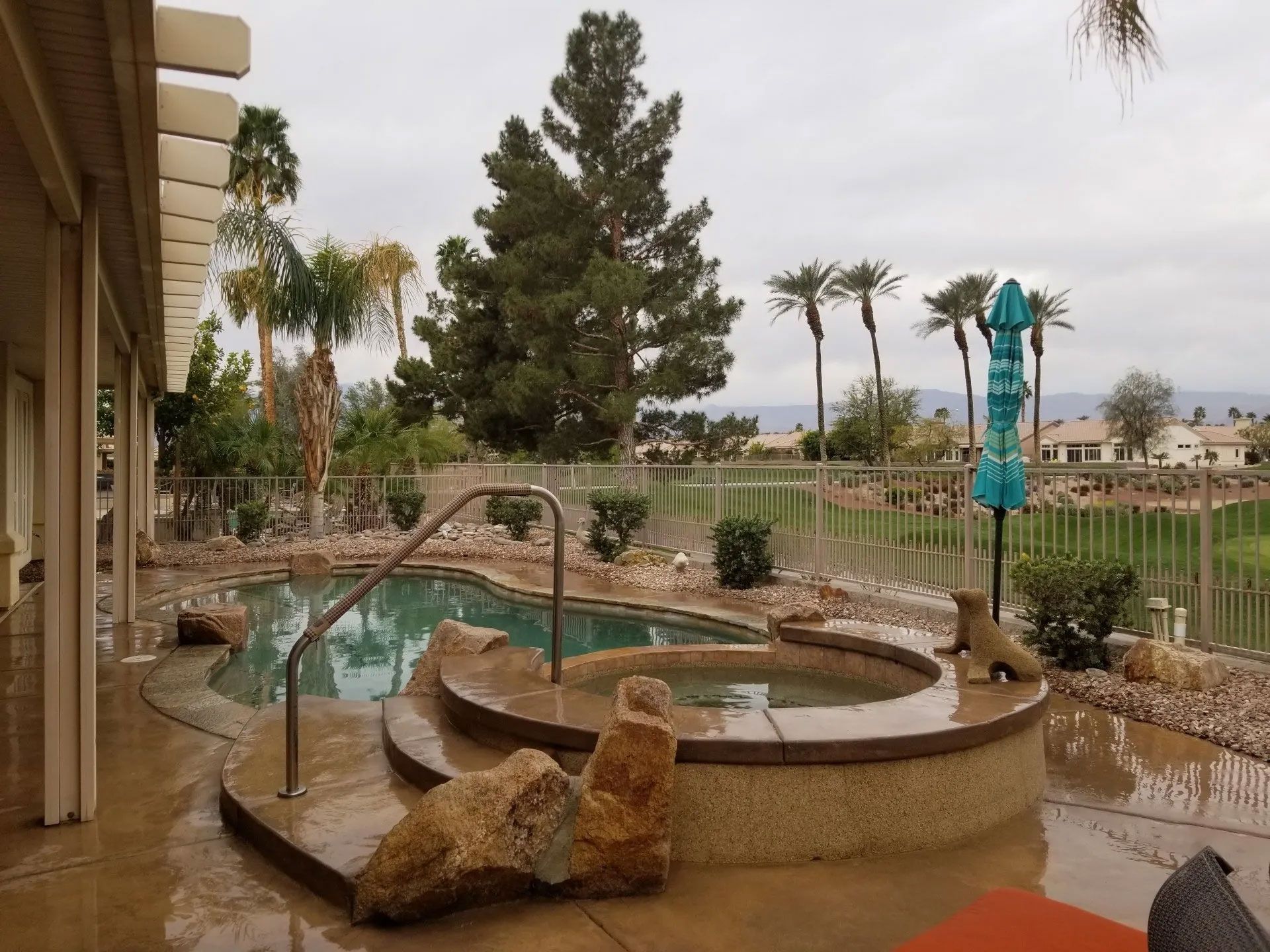 A swimming pool with a hot tub in the middle of it