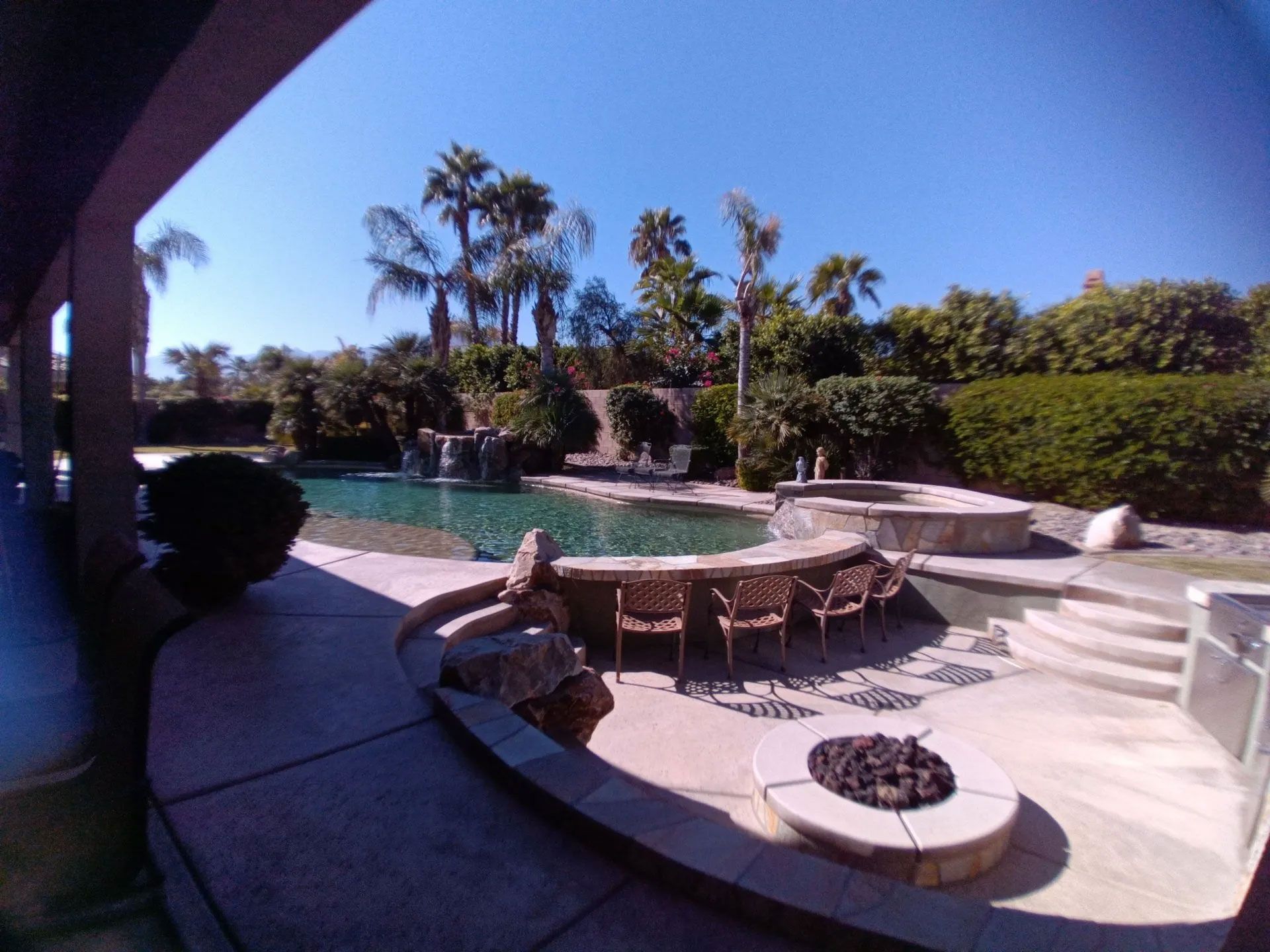 A patio with a fire pit and a swimming pool
