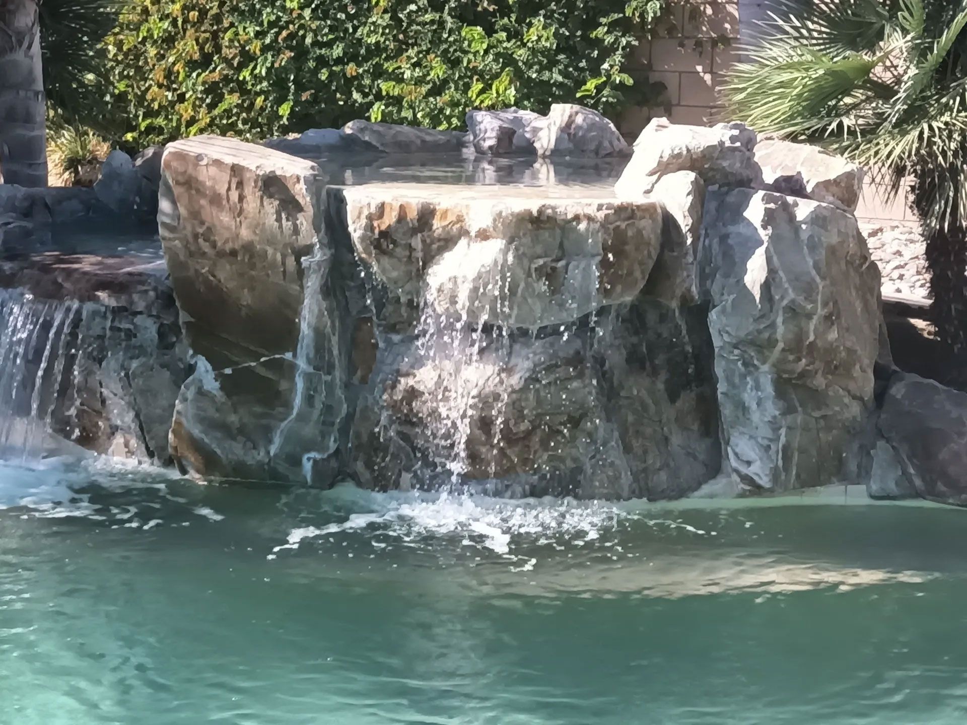 A waterfall in the middle of a swimming pool