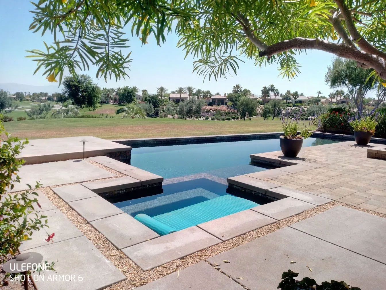 A large swimming pool with a hot tub in the middle